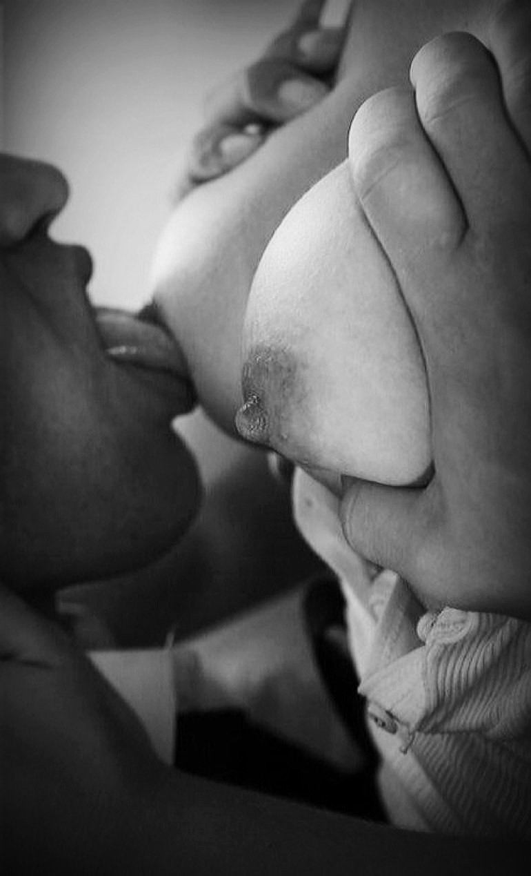 Человек целовать грудь женщины