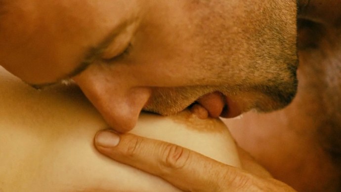 Мужчина ласкает грудь женщины
