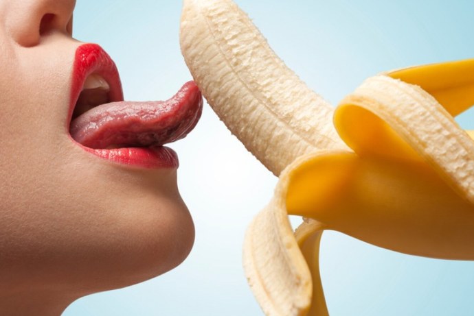 Девушка ест банан