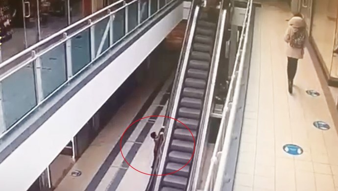 Девушка в юбке на эскалаторе