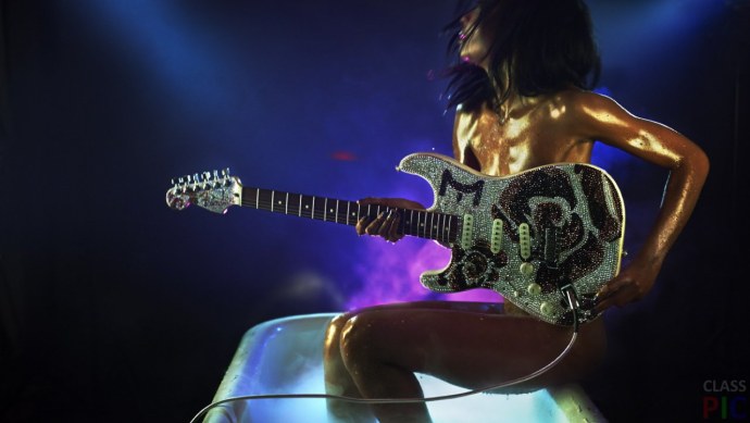 Девушка с гитарой на сцене